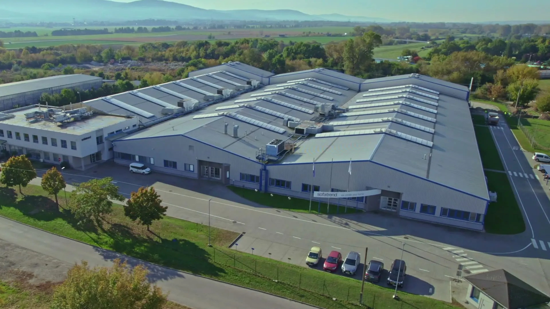 Luftaufnahme des sofatrend Werks in Topoľčany, im Hintergrund die Berge